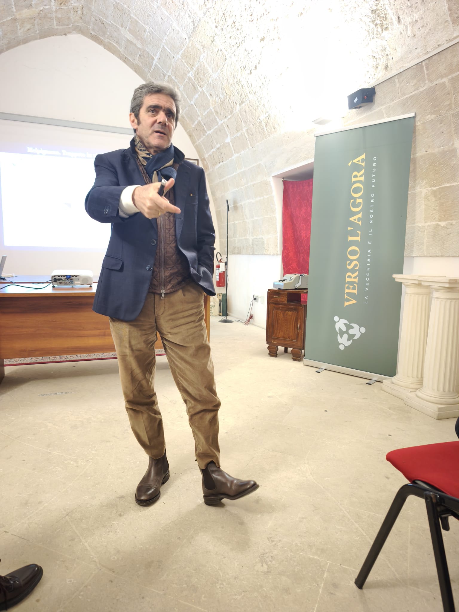 Relatore con banner Verso l'Agorà